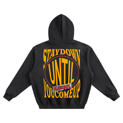 Black oversized streetwear hoodie with bold yellow Stay Down Until You Come Up PLAYAZ INTL graphic on the back